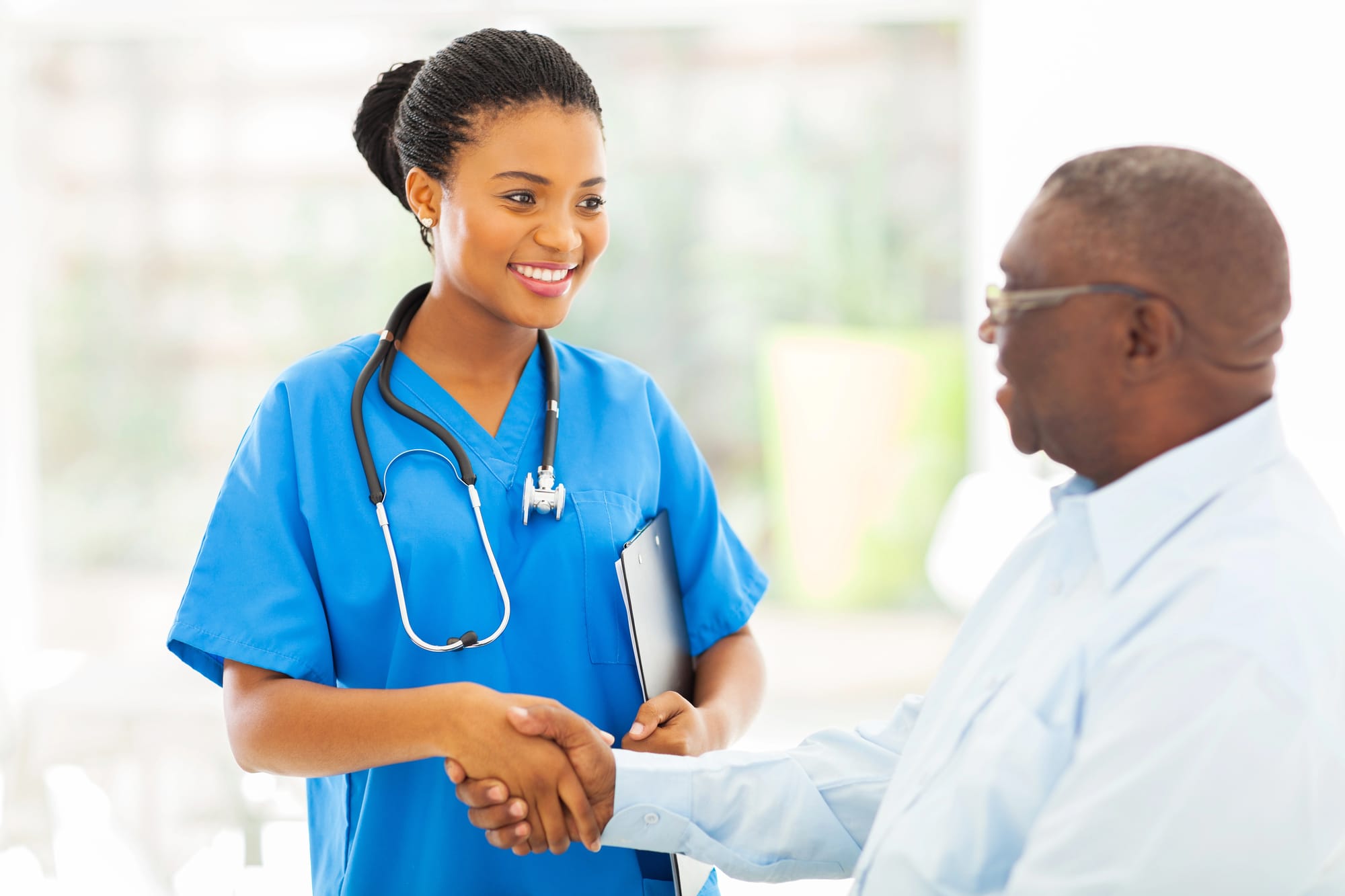 Friendly nurse greeting a patient with a handshake at a medical center, representing professional care by medical centers and specialists.