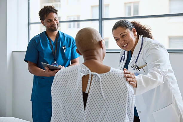 Doctor and nurse supporting a patient during a cancer care consultation at a medical facility in St. Ann.