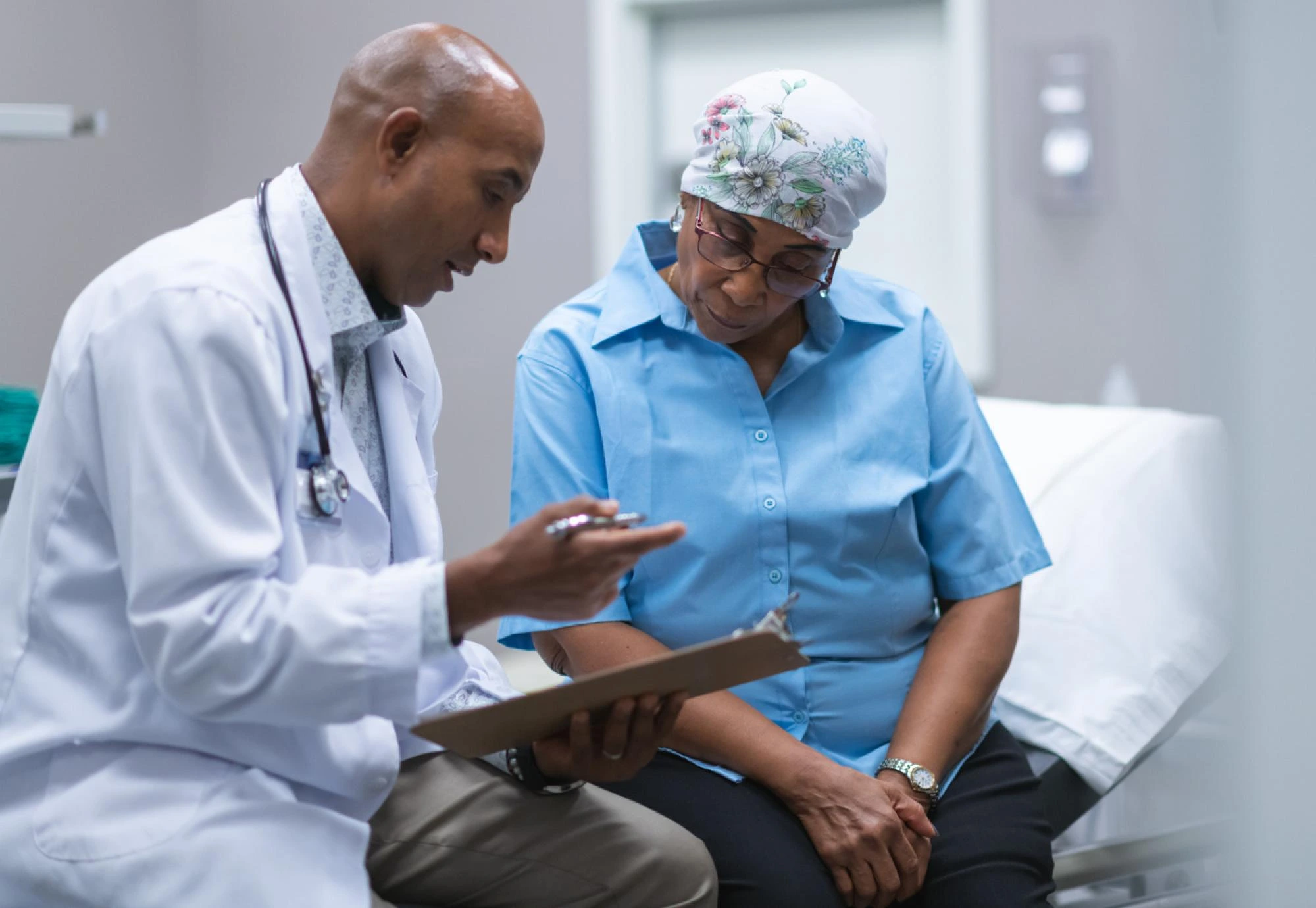 Doctor discussing a Medical Oncology Treatment plan with a patient in a clinical setting.